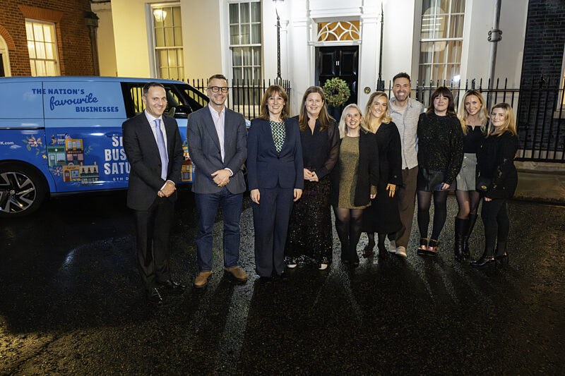 The Small Business Saturday team and guests outside the door of 11 Downing Street at night, beside the Nation's Favourite Businesses van